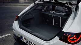 Das Bild zeigt einen wei&szlig;en Mercedes-Benz CLA Shooting Brake, der auf einer breiten, nahezu leeren Stadtstra&szlig;e f&auml;hrt. Moderne Geb&auml;ude umgeben die Szene, das Licht wirkt weich und fr&uuml;hmorgendlich. Der Wagen ist seitlich zu sehen und vermittelt Dynamik sowie Eleganz.