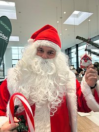 Der Weihnachtsmann h&auml;lt einen Anh&auml;nger in die Kamera