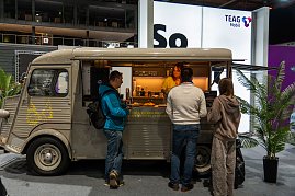 Foodtruck auf der Automesse, Besucher bestellen Snacks.
