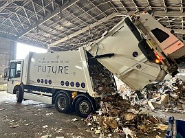 M&uuml;llfahrzeug kippt Papier- und Kartonabf&auml;lle in einer Recyclinghalle ab.