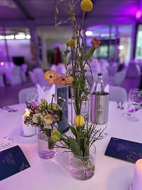 Gedeckter Eventtisch mit floraler Dekoration und stimmungsvoller Beleuchtung.