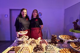 Zwei Servicekräfte hinter Dessertbuffet mit Pralinen und Gebäck.