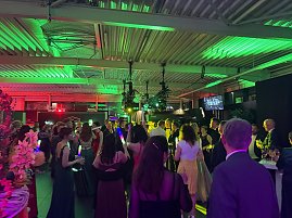 Dynamische Partyszene: Die Tanzfläche ist gut gefüllt, viele Gäste feiern ausgelassen und halten leuchtende LED-Sticks in der Hand.