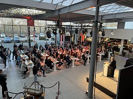 Der Blick von der Galerie auf die Veranstaltung: Helmut Peter am Rednerpult, viele G&auml;ste h&ouml;ren ihm zu.