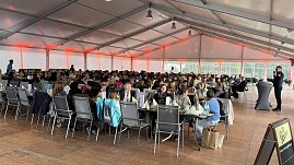 Voll besetztes gro&szlig;es Gastronimiezelt mit vielen langen Tafeln.