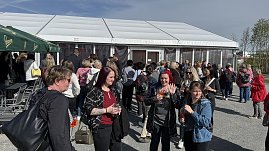 Mehrere Frauen stehen vor einem gro&szlig;en Zelt und unterhalten sich.