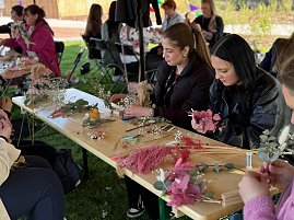Einige Frauen basteln Trockenblumenkr&auml;nze.