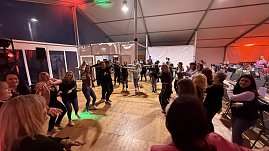 Viele Personen auf einer Tanzfl&auml;che am Abend.