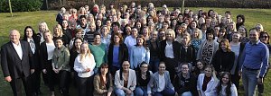 Gro&szlig;es Gruppenfoto im Freien bei der Frauentagsfeier der Autohaus Peter Gruppe. Zahlreiche Frauen und einige M&auml;nner stehen dicht beieinander auf einer Wiese, im Hintergrund kahle B&auml;ume an einem sonnigen Tag.