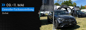 Veranstaltungsbanner und Fahrzeugpräsentation: Schwarzes Banner mit Text 09.–11. Mai, Gewerbe-Fachausstellung Zerbst neben einem ausgestellten grauen Mercedes-Benz SUV vor dem Stand der Autohaus Peter Gruppe.