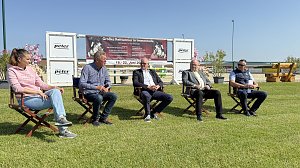 F&uuml;nf Personen sitzen auf St&uuml;hlen im Freien auf dem Reitplatz in Immenrode w&auml;hrend der offiziellen Pressekonferenz zum Reitturnier 2025. Hinter ihnen ist ein gro&szlig;es Banner mit Informationen zum Turnier vom 18. bis 22. Juni zu sehen. Sonniges Wetter und gr&uuml;ne Rasenfl&auml;che pr&auml;gen die Szene.