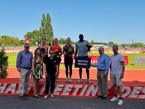 Siegerehrung beim Leichtathletik-Meeting Anhalt 2025: Sportlerinnen und Sportler stehen auf dem Podium mit Blumen in der Hand, einer h&auml;lt ein Schild mit der Aufschrift �Meeting Rekord�. Vor dem Podium posieren mehrere Erwachsene, im Hintergrund sind Laufbahn und Zuschauertrib&uuml;nen.