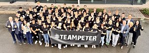 Gruppenfoto der 63 neuen Auszubildenden der Autohaus-Peter-Gruppe vor dem Mercedes-Benz-Autohaus in Nordhausen. Alle tragen schwarze #TeamPeter-T-Shirts und halten einen Banner mit dem Schriftzug #TEAMPETER. Geschäftsführung und Ausbildungsleitung stehen am Rand, alle lächeln und zeigen Daumen hoch.