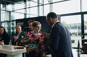 Lilly Hecker, frisch ausgebildete Automobilkauffrau und Jahrgangsbeste, erh&auml;lt einen Blumenstrau&szlig; von Gesch&auml;ftsf&uuml;hrer Andreas Peter. Im Hintergrund applaudieren weitere Mitglieder der Gesch&auml;ftsf&uuml;hrung.