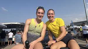 Zwei Sportlerinnen sitzen auf der R&uuml;ckbank eines Mercedes-Cabrios und l&auml;cheln in die Kamera. Beide tragen Sportkleidung, die linke ein gelb-graues Top, die rechte ein gelbes Shirt. Im Hintergrund Zuschauer und Zelte beim Leichtathletikmeeting in Sondershausen.