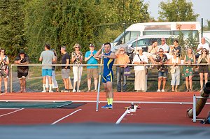 Stabhochspringer im blau-gelben Trikot steht mit Stab in den H&auml;nden am Anlauf, bereit f&uuml;r seinen Versuch. Im Hintergrund Zuschauer am Rand der Laufbahn.