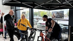 Fachberatung am Stand von Zweirad Illhardt im Autohaus Autowelt Peter. Ein Berater erkl&auml;rt zwei Besuchern verschiedene Fahrr&auml;der. Im Hintergrund ist ein �koda-Werbeplakat zu sehen.