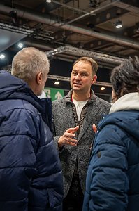 Geschäftsführer der Autohaus Peter Gruppe hält Beratungsgespräch auf der Automesse.