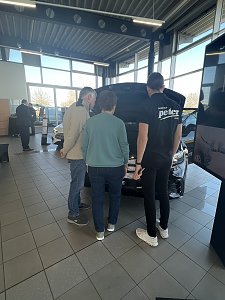 Gäste des Unternehmerfrühstücks schauen sich gemeinsam mit einem Mitarbeiter vom Peter-Team den neuen GLC an.