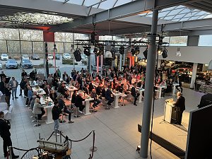 Der Blick von der Galerie auf die Veranstaltung: Helmut Peter am Rednerpult, viele G&auml;ste h&ouml;ren ihm zu.