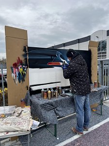 Graffiti-Künstler Alex Sitt vor einer Leinwand, der er gerade besprüht.