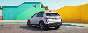Weißer Škoda Epiq in Heckansicht mit schwarzem Dach und modernen LED-Rückleuchten vor gelber und türkiser Kulisse.
