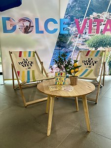 "La Dolce Vita"-Wand, davor 2 Liegestühle und ein kleiner Holztisch mit sommerlicher Tischdeko