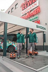 Škoda Roadshow Bühne mit einem bunt beklebten Fahrzeug; davor 2 Skoda Moderatoren mit Mikros.