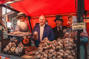 Knoblauchstand mit mehreren Personen dahinter, die meisten in Kostümen.