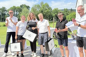 Gewinnerteam präsentiert Geschenktaschen bei der Preisverleihung auf der Clubhausterrasse.
