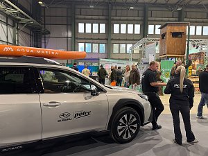Autohaus Peter Messestand in der Halle mit einem Subaru und Personen daneben, die sich unterhalten