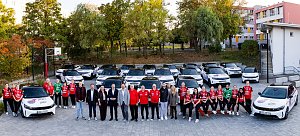 Spielerinnen des Th&uuml;ringer HC und Vertreter der Peter Gruppe posieren gemeinsam vor einer Flotte wei&szlig;er Opel-Fahrzeuge im THC-Design.