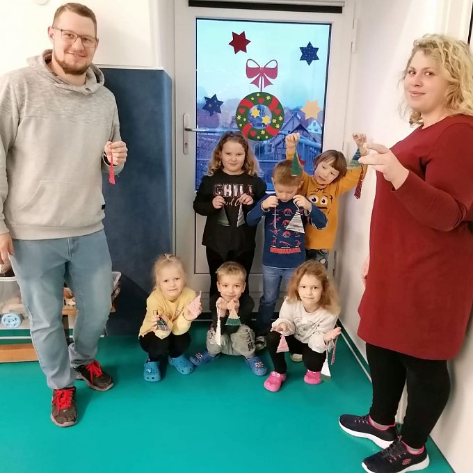 Kita-Leiter Markus Klaan und Erzieherin Victoria Wedler sind stolz auf ihre kleinen K&uuml;nstler. Alle zeigen die gebastelten B&auml;umchen.