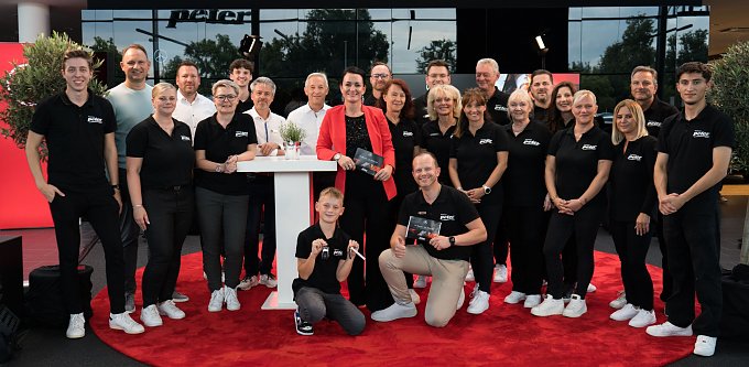 Teamfoto mit 24 Personen vom Autohaus Peter beim He�s Mercedes Abend. Die meisten tragen schwarze Polohemden mit Peter-Logo, alle l&auml;cheln in die Kamera.